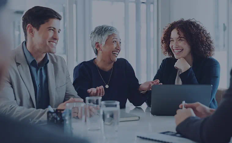 Honesty A group of business people laughing at a conference table.